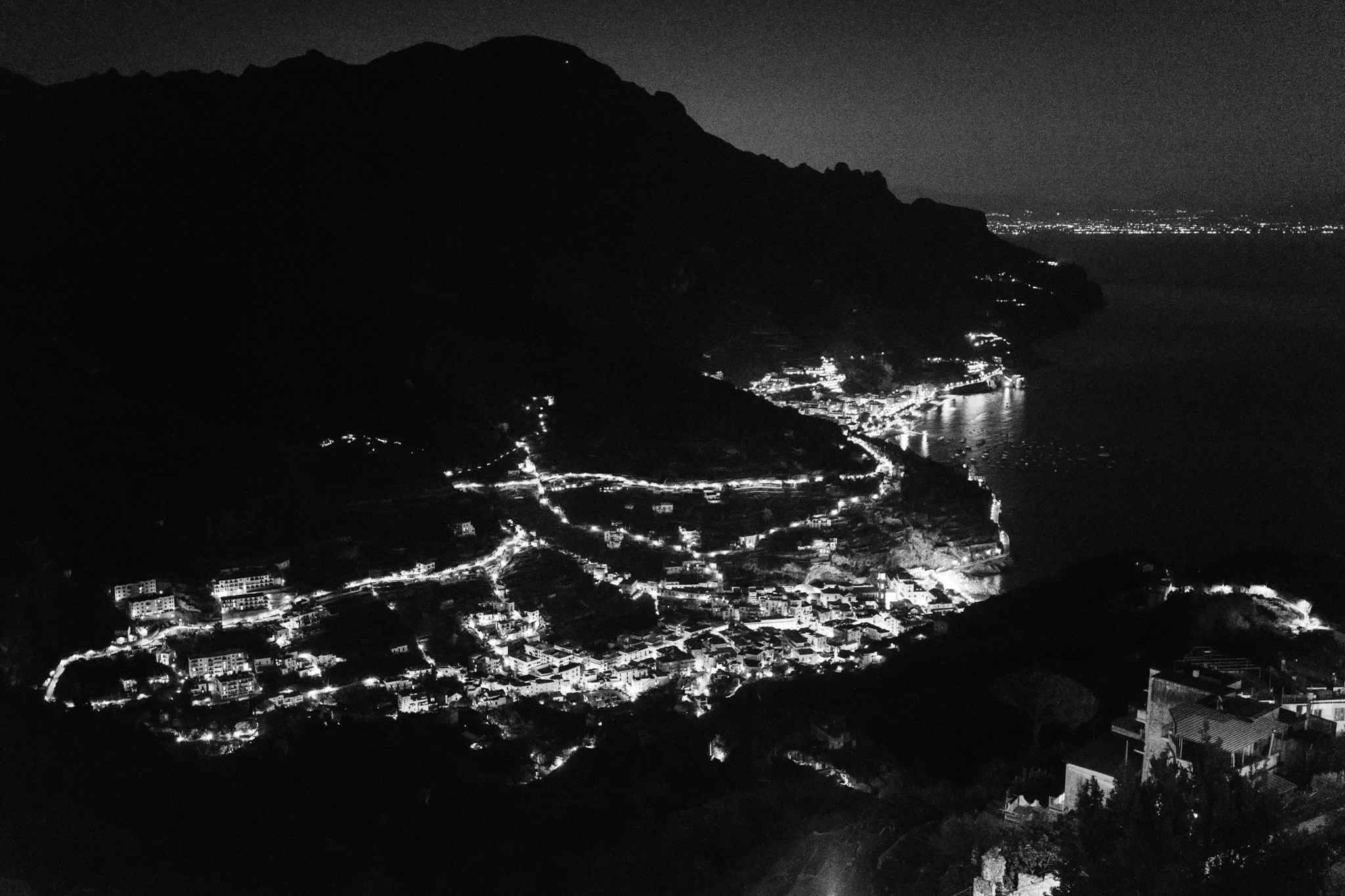 Night view over the lit coastal villages and winding roads of the Amalfi Coast from Ravello